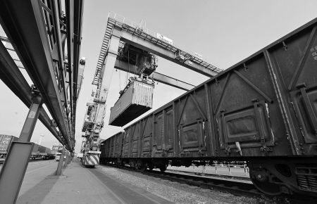 昨天下午，在宁波港码头，一批集装箱被直接吊上火车运往外地。