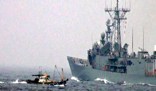 台湾海军22日上午实施反潜与反快艇作战操演，突然有渔船闯入演习区，场面惊险。图片来源：台湾《联合晚报》
