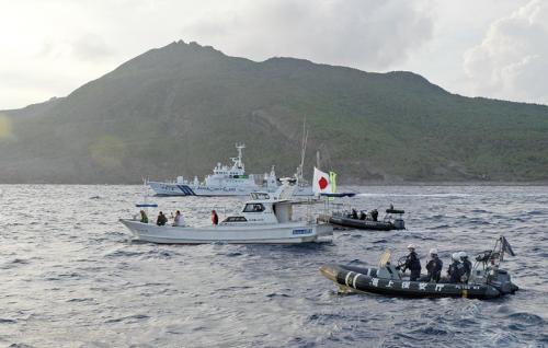 18日，日本右翼团体乘坐的渔船（中）进入钓鱼岛附近海域后被日海上保安厅船只包围并勒令离开。