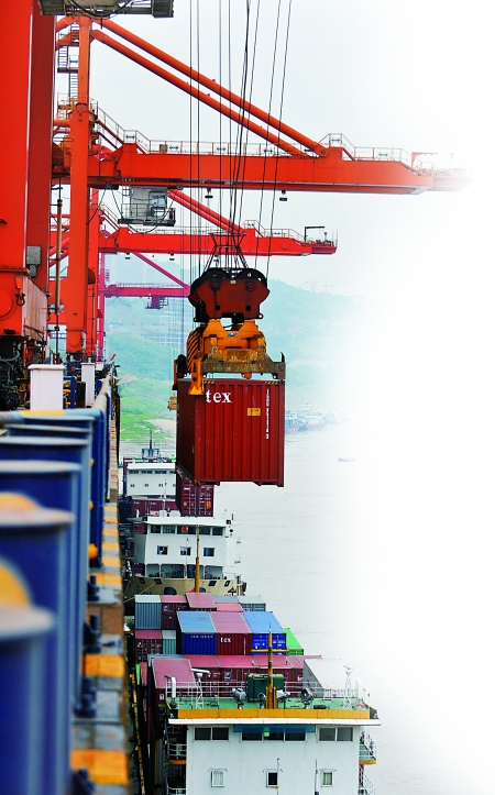 大型吊车在向果园港泊位上的货船吊装货柜 新华社图