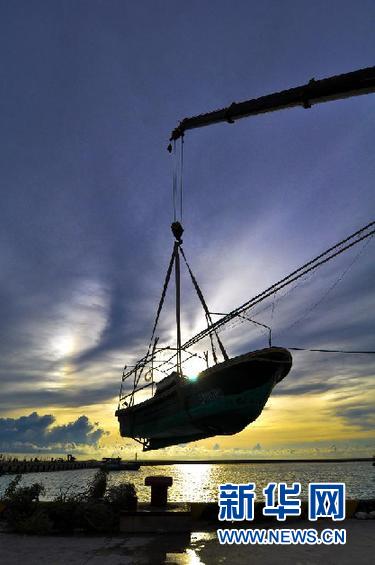 9月14日，在海南省三沙市，一艘渔船被吊往岸边避风。