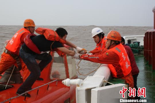 图为救助人员正将遇险船员转移至“东海救111”轮。