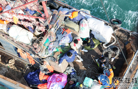 救生员准备吊起陪同人员救助辽庄渔85037”渔船重伤船员