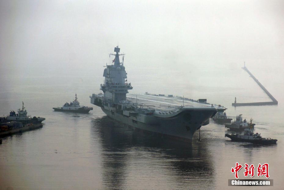 数艘拖轮正在将国产航母拖离大连造船厂码头。中新社记者杨毅摄